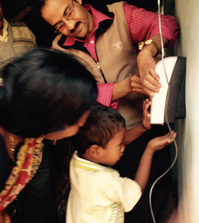 a young boy holding his hand under a sensor while his parents look on